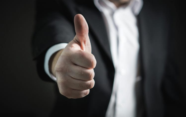 Image of a man giving a thumbs up, indicating that he is giving his support to someone.