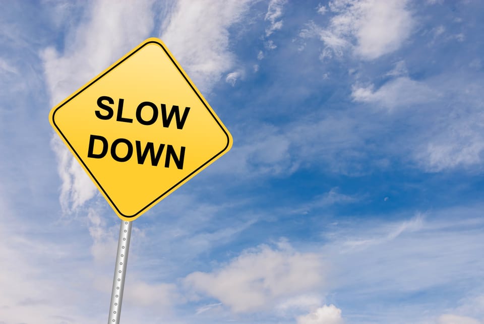 Picture of a stop sign that says "Slow Down"